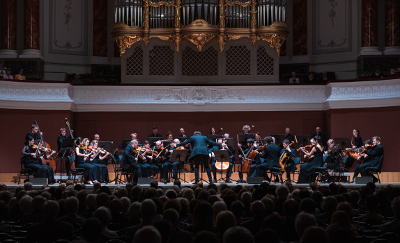 Maxim lead the Orchestra at the proms. The organ is visible and the backs of heads.