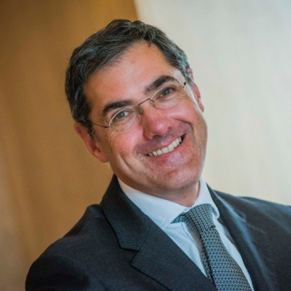 Charlie MacQuaker smiling at the camera, with the image angled diagonally.