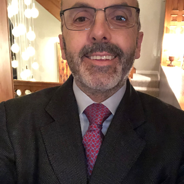 Close-up of Mark Urquhart wearing a suit, smiling at the camera.