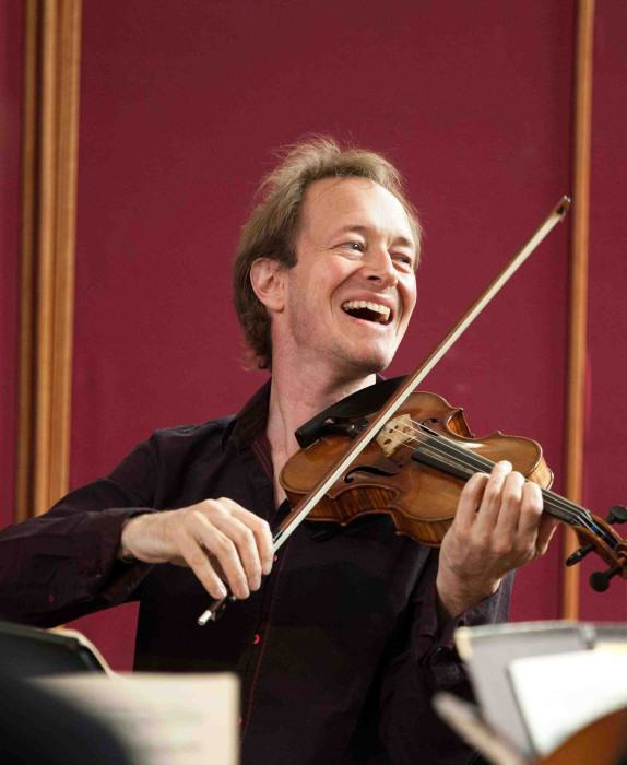 Violinist Anthony Marwood plays the violin, laughing as he looks to his left.