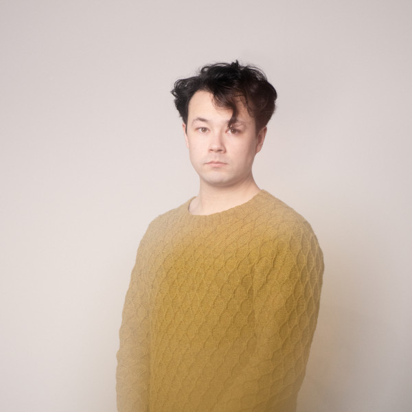 Sean Shibe wears a yellow jumper