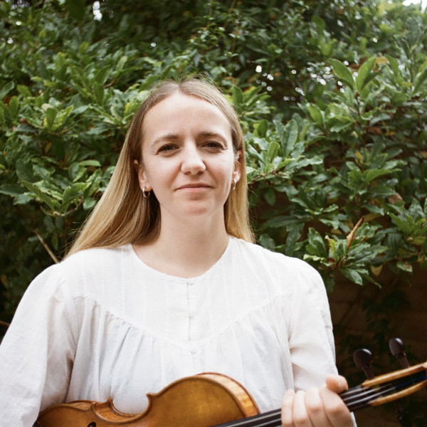 Hatty has long blonde hair and holds her violin