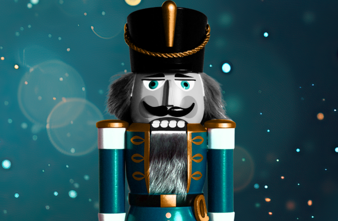 A blue nutcracker soldier is featured with a blue glistening backdrop.