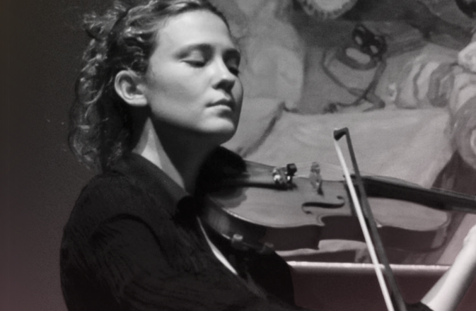 Lorenza Borrani plays the violin with an renaissance style painitng behind her.