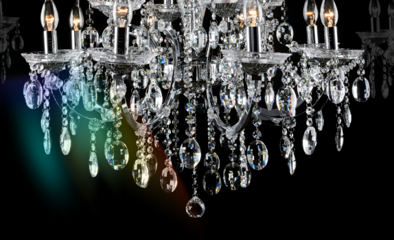 A diamond-like chandelier hangs down with a prism of colour shining from it.