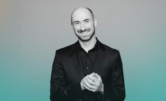 Peter Whelan wears a black shirt and smiles.