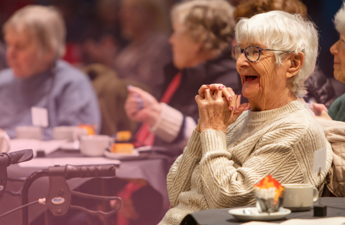 An audience member of the Tea Dance concert smiles with delight.