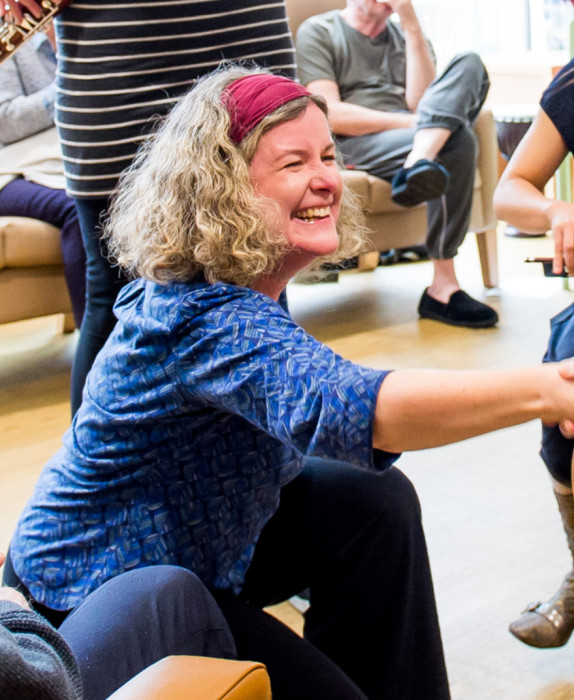 Jane bentley reached and shakes a hand with an older man. The image is cropped on Jane smiling.