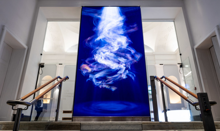 Large screen display located at the top of the stairs leading up to the entrance hall.