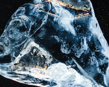 A photograph of a glistening diamond set against a dark background.