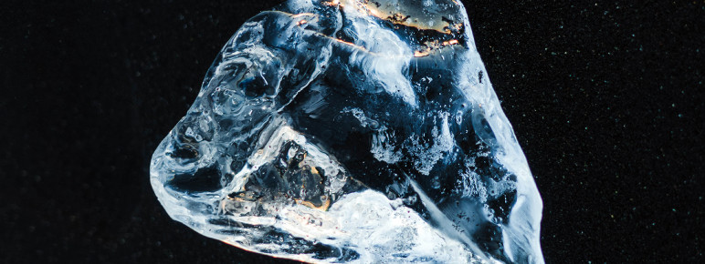 A photograph of a glistening diamond set against a dark background.