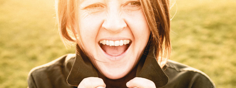 A woman laughing with a jumper on